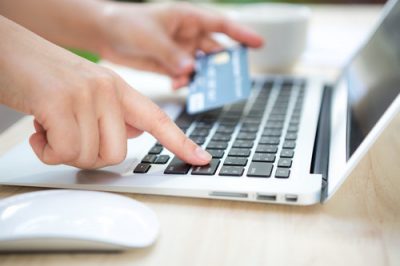 Hands holding a credit card and using laptop computer for online shopping on your website