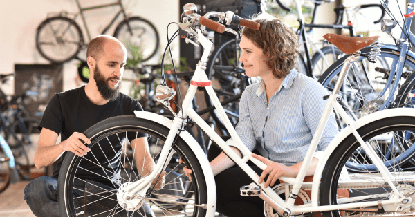 Bike shop employee helping a woman purchasing a bike